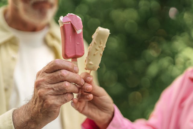 two people cheering with ice lollies 