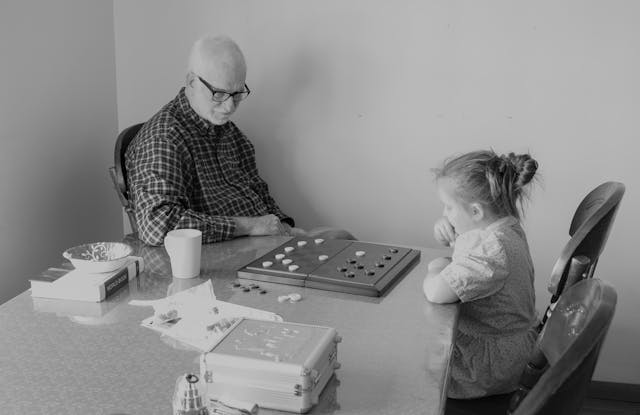 child playing board game with senior in care home