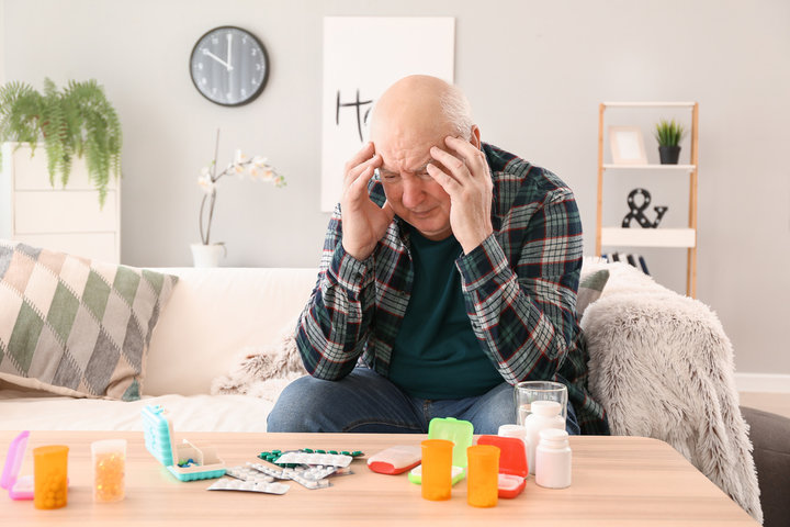man looking distressed with tablets around him