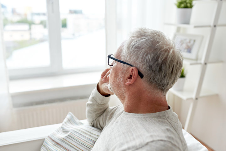 older man alone staring out the window