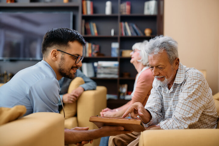 resident with carer in lounge of care home